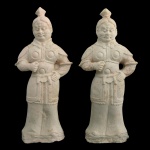 Conjunto de 2 estatuetas em cerâmica retratando guerreiros em armadura. Apresenta uma fisionomia austera e focada, em pé, com as mãos posicionadas como se estivessem segurando algum objeto ou arma. Era frequentemente utilizadas como bens espirituais. 40 x 26 cm.