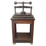 Séc. XIX - Prensa manual para impressão de gravuras, documentos e encadernações, com robusta estrutura quadrangular em madeira lisa. Tampo alto sustentando grossa placa em aço liso, com sistema de haste com rosca ao centro, ladeada por colunatas e encimada por barra giratória de pressão horizontal com pegas esféricas. Atualmente muito usada nas decorações de grandes casa ou fazenda. 110 x 55 x 41 cm.