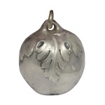 Chocalho infantil  em metal moldado no formato de fruta recamada por folhas e encimada por argola. 5 x 4 cm.