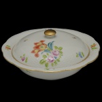 HEREND  Elegante legumeira de forma oval em porcelana húngara, ornamentada em policromia floral e filetes a ouro. Marcas da manufatura sob as bases. 11 x 21 cm.