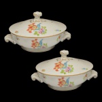 HEREND  Elegante Par de legumeiras circulares baixas, em porcelana húngara ornamentada em policromia floral e filetes a ouro. Bojos retos ladeados por alças em volutas filetadas, apoiados em bases retraídas. Tampas levemente abobadadas, encimadas por pegas torcidas. 16 x 28 x 24 cm.