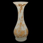 Vaso de formato balaústre em opalina leitosa, Apresenta rica ornamentação a ouro com adornos florais, estilizações e volutas. Bojo abaulado encimado por gargalo em corneta com borda lisa. Base retraída e circular. 34 x 12 cm.