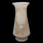 Vaso de formato balaústre em opalina leitosa, Apresenta elegante ornamentação floral em tons prateados e dourados, realçada por filetes a ouro. Bojo cônico reto, encimado por gargalo em corneta revirada com borda lisa. Base retraída, alta e circular. 30 x 14 cm. Fio de cabelo na borda.