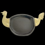 Travessa para assados no formato de ave, em acrílico dourado, com parte central preta de formato de cabeça e rabo como pega. 4 x 48 x 24 cm.