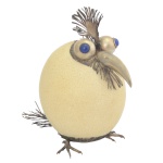 Original escultura representando pássaro, construída a partir de um ovo de avestruz, sobre o qual se colocou um par de olhos, um bico, um par de patas em metal e uns penachos imitando penas. 17 x 12 x 13 cm.