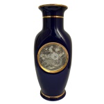 Vaso japonês em porcelana, estilo Kutani, azul cobalto e ouro - Elegante vaso em porcelana japonesa, destacando-se pelo intenso fundo azul cobalto e rica decoração com aplicação de ouro, incluindo medalhão central em relevo com composição floral. 26 cm. 8 cm (base)