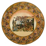 Prato Japonês estilo Satsuma  Cena de Gueixas  Período Showa (c. 19201950) - Belíssimo prato decorativo em porcelana japonesa no tradicional estilo Satsuma, Apresenta rica decoração policromada com cena de gueixas em ambiente paisagístico, composta por elementos florais e arquitetônicos típicos da iconografia oriental. A borda é amplamente ornamentada com motivos estilizados em tons vibrantes, realçados por delicada aplicação de ouro, característica marcante desta tipologia. Peça produzida durante o período Showa (c. 19201950), com pintura manual e forte apelo estético. 26 cm