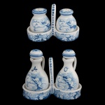 DOLCE GABBANA - Conjunto em cerâmica de superficie branca com decoração em azul ornamentado por putto segurando pergaminho. O design apresenta motivos barrocos, incluindo um cupido e uma faixa com a inscrição Dolce & Gabbana. Peças que combina elementos decorativos tradicionais com branding de marca luxuosa. Composto por saleiro e pimenteiro (8 x 6 cm) e 10 x 16 cm (MT) e porta vinagre e azeite (14 x 9 cm garrafinhas) e 10 x 16 cm (MT).