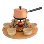 Aparelho de fondue italiano em cobre constando de: Bandeja de madeira (5 x 44 cm), bowls de cerâmica (5 x 10 cm), panela (10 x 15 cm / 10 x 30 cm com cabo) e espetinhos (12 cm).