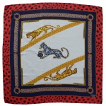 HERMÉS, Paris, France. Lenço em 100% seda. Apresenta uma estampa icônica de panteras sobre faixas diagonais douradas. Borda vermelha com padrão animal print e um fundo central claro com detalhes em azul marinho.  86 x 86 cm.