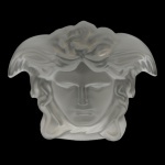 ROSENTHAL. Design da Maison VERSACE. Modelo Medusa Lumiére  Peso de papel em cristal fosco na forma de máscara acetinada aplicadas em alto relevo. 9 x 9 cm.