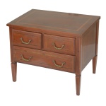 Pequena meia cômoda em madeira nobre, estilo inglês, ornada por frisos em parqueterie. Tampo retangular liso e saliente, apoiado em caixa reta. Frente apresentando par de gavetas alinhadas sobre gavetão. Pernas retilíneas, de secção quadrangular, levemente afinadas. 50 x 60 x 40 cm. Sinais de uso e do tempo, com algumas manchas no tampo.