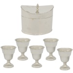 Conjunto de peças em metal prateado, sendo: A) Caixa para chá de formato ovalado e liso. Pega da tampa na forma de pinha. No verso marca da manufatura Sheffield Plate (13 x 14 x 9 cm). B) Conjunto de 5 taças (8 x 6 cm).
