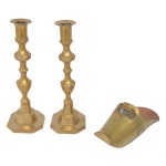 Lote constando de 3 peças em metal amarelo, sendo: A) Par de castiçais. Colunas com anelados e base octogonal (25 x 8 cm). B) Sapata lisa. (23 x 8 cm).