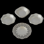 Lote constando de 4 fruteiras em metal prateado, sendo: 1 quadrada (4 x 22 x 22 cm) 2 redondas (4 x 24 cm) e 1 com borda vazadas e pés (8 x 30 cm), Sinais de uso e do tempo