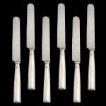 Conjunto de 6 facas em metal prateado. Apresenta desgastes nas lâminas e no cabo.