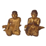 Raro par de estatuetas birmanesas do século XVIII, esculpidas em madeira revestida por folhas de ouro sobre fundo em laca rouge de fer. Apresentam monges budistas ajoelhados de lado, vestindo Kasaya, longos mantos monásticos, realçados por poucos adereços como colares montados com pedaços de vidro espelhados. São raros os do século XVIII. Os do século XIX são muito mais decorados com grandes áreas cobertas por mosaicos em vidros coloridos. 22 x 20 x 22 cm.