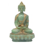 Escultura, possivelmente tailandesa, em pedra verde, com realces dourados, representando Budha em atitude de meditação, com as pernas cruzadas e as mão reunidas segurando o pote das Almas, símbolo de proteção e longevidade. Base ornada por friso com folhas de lotus, assentada sobre degrau retraído e liso. 20 x 13 x 10 cm.
