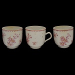 Conjunto de 3 xícaras para café, em porcelana chinesa, com bojos retos decorados em policromia. Apresentam arranjos florais e bordas com finos frisos. Alças laterais em asa. 7 x 9 cm.
