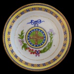 IMPÉRIO BRASILEIRO  China. Companhia das Índias. Séc. XIX  Prato em porcelana chinesa com temática histórica. Apresenta no centro um Brasão do Império Brasileiro. Padrão floral predominando o vermelho, o verde e o azul. 16 cm.