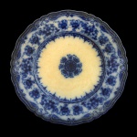 RIDGWAY POTTERIES, Flow Blue. England - Prato circular em louça inglesa do séc. XIX. Apresenta decoração azul borrão e reserva central com desenhos florais. Marca da manufatura no verso.