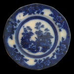 ENGLAND. Séc. XIX - Prato em louça inglesa de formato circular ondulado de design Chinosesrie, apresentando paisagens asiáticas com pagodes, árvores e pontes em azul borrão. Marca da manufatura no verso.