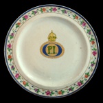 D. PEDRO I E COROA IMPERIAL - CHINA. Companhia das Índias. Séc. XIX - Prato em porcelana chinesa Cia das Índias. Centro apresentando monograma com as iniciais de D Pedro I e Coroa Imperial. Borda com um padrão floral detalhado. 24 cm.