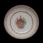 D. PEDRO ANTONIO DE PINA MANIQUE NOGUEIRA MATOS ANDRADE (1773-1839). Governador e Capitão Geral de São Paulo. Séc. XIX - Pires em porcelana chinesa da Companhia das Índias. Apresenta ao centro Brasão Heráldico, escudo central com divisões de cores e padrões. Borda apresentando pequenas flores e, tom de rosa, azul e laranja, com folhagens em tom alaranjado. 14 cm.