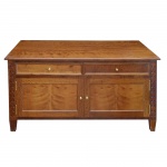 Cômoda em madeira nobre com belos veios naturais, de formato retangular, realçadas por largas molduras. Tampos lisos e salientes, apoiados em caixas retas com frentes apresentando 2 gavetas alinhadas sobre par de portas. Interiores com prateleiras. Pernas laterais retilíneas, ornamentadas por frisos geométricos e pés levemente afinados. 65 x 115 x 60 cm.