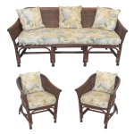 Conjunto de sofá para 3 lugares e par de poltronas, com estruturas em bambu. Encostos arqueados em corbeille, acoplados a braços revirados. Pernas retilíneas, reforçadas por arcos e com as traseiras levemente inclinadas. Forração dos encostos em palhinha da Índia. Acompanham almofadas em tecido em floral com fundo marfim. No estado. 82 x 60 x 57 cm.