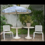 Par de mesas de cimento, pintados na cor branca. Acompanham 2 cadeiras brancas de plástico e um ombrelone. 75 x 78 cm (mesa). Apresenta sinais de uso e do tempo. Este lote encontra-se na casa do comitente no Alto da Boa Vista, SP. A retirada deverá ser agendado previamente com o nosso escritório no telefone 11.5044.1228.