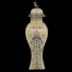 Potiche em cerâmica artística decorada à mão com motivos florais e detalhes em ouro. Pega da tampa na forma de cão. 42 x 13 x 13 cm.