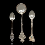 Conjunto de colheres para café em prata de teor 900 mls com cabos lavrados e cinzelados, sendo, A) 13 colheres rematadas por brasões de Portugal sob coroas, sendo uma maior com bojo circular para açúcar, apresentando marca de prateiro de São Paulo. B) 12 rematadas por adornos florais realçadas por pequenos cabochões azul turquesa. 