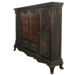 Grande armário vitrine Book case, em madeira nobre, de formato retangular, profusamente esculpido e ornado com almofadas, frisos florais e painéis realçados por composições com ramos floridos. Frente apresentando 4 portas, sendo 2 laterais centralizando estante com parte superior envidraçada revelando prateleiras internas. Frontão saliente e reto, decorado por friso estilizado. Base com saia ondulada, apoiada sobre pés baixos e revirados em volutas. 191 x 234 x 48 cm. Este lote encontra-se na casa do comitente no Alto da Boa Vista, SP. A retirada deverá ser agendado previamente com o nosso escritório no telefone 11.5044.1228.