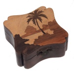 Caixa porta joias em madeira artesanal. Tampo com marqueteire apresentando coqueiro, montanhas e mar. Estrutura de forma estilizado com fecho metálico. 4 x 10 x 10 cm.