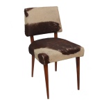 Cadeira Retrô, com estrutura em madeira lisa levemente recurva. Encosto retangular e arqueado, apoiado em assento quadrangular. Forração em pele de boi malhada bege e marrom escuro. Pernas retas e lisas, levemente afinadas. Modelo conhecido como Pé de Palito. Década de 1950-1960. 70 x 44 x 42 cm.