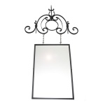 Espelho retangular de parede com moldura simples, sustentada por original suporte metálico lavrado com volutas ladeadas por arabescos. 132 x 82 cm (MT). 70 x 50 cm (espelho). 57 x 88 cm (ferragens).