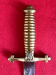 Império Brasileiro. Espada de músico. Apresenta punho em latão com símbolo de harpa no próprio punho, não possui guarda. Medidas aprox.: total 64 cm, lâmina 52 cm.