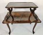 GALLÉ, ÉMILLE. ASSINADA. França início séc. XX. Extremamente raro e importante móvel francês ART NOVEAU TEA TABLE por ÉMILLE GALLÉ com exótica decoração em marcheterie com vários tipos de flores e inserções de borboletas. Apresenta-se sobre quatro graciosos pés recurvos com acabamentos em vazados de onde parte o primeiro PLATÔ (TRAY). Magnífico trabalho recurvo nas bordas e na marchetaria com motivo de flora. Esse platô (tray) possui assinatura Gallé. Pegas em bronze estilizadas no mais ouro estilo ART NOVEAU de onde partem quatro magníficos prolongamentos dos pés também vazados de qualidade de entalhe também impressionantes, os quais suportam o platô (Tray) final com riquíssimo trabalho em marcheterie com elementos florais e graciosas borboletas. Medidas aprox. 84 cm de altura total, 93 x67 cm do primeiro platô e 72 x 46 cm o segundo.