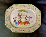 Cia das Índias Séc XVIII. Excepcional e raríssima travessa em porcelana chinesa com esmaltes Família Rosa de excepcional qualidade. Apresenta rico trabalho realçado à ouro com monumental e rara representação BUDDHA DA FELICIDADE ricamente trajado e sentado em gracioso jardim. Rara paleta de cores. Apresenta em seu verso vestígios de etiquetas e marcação número 51, coleção ARI BRAGANÇA DE BOURBON. Item muito raro para coleção. Medidas aprox. 42 x 23 cm.