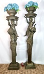 EUROPA Séc. XIX/XX. Lindíssimo PAR DE ESCULTURAS em BRONZE. Casal em forma de cariátides e cada um com uma criança nos ombros e arrematando vaso floreira na parte superior. Peças muito decorativas tanto para interior quanto exterior. Apresentam diferença de altura em função da fundição a mão. Medidas aprox. 170 cm de altura cada.