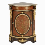 Belo dunquerque de canto, francês ao gosto de André Charles Boulle construído em madeira ebanizada com placagens em tartaruga loura sob aplicações em bronze cinzelado, apresenta porta anterior abaulada com uma prateleira interna. Riquíssimos adornos em bronze ormolu destacando duas elaboradas cariátides femininas com "bouquets" de flores e guirlandas. Tampo em mármore rajado com frente boleada. Provavelmente século XVIII. Medindo 107cm de altura, 53cm de largura nas laterais e 77cm na parte frontal. Marcas do tempo.