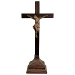 ARTE SACRA - Antigo cristo de pousar provavelmente mineiro em madeira policromada com belíssima anatomia com características do século XVIII, sobre cruz em jacarandá posterior a sua época, medindo 57cm de altura e 27cm de largura.