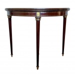 MOBILIÁRIO - Mesa aparador conversível em mesa em madeira de lei com apliques em bronze e tampo conversível para uso como mesa de 4 lugares, apresenta rasgo no couro original, imperceptível quando fechada. medindo 92x46cm com tampo fechado, 92cm de diametro aberta e  e 75cm de altura.