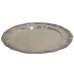 PRATA DE LEI - Sousplat em prata de lei portuguesa contratada águia de primeiro título de teor 916 e marca do prateiro A. Gomes medindo 27cm de diâmetro e pesando 600 gramas. Apresenta amassado.