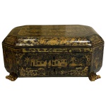 Caixa chinesa em madeira com pintura em laca negra e ouro denominada caixa charão para costura com diversos instrumentos com agulhas carretéis e compartimentos e pés em garra medindo 15cm de altura, 32cm de largura e 25cm de comprimento. 