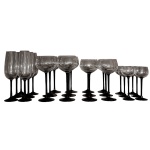 Conjunto de taças em cristal ao estilo das peças em murano com hastes em cristal moldado na cor preta e bojos em cristal translúcido para 6 pessoas, composto de 6 taças para champanhe, 6 taças para água, 6 taças para vinho e 6 taças para licor. Uma taça para vinho possui bicado.
