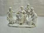 Grande figura decorativa em porcelana branca representando quatro personagens rurais em cena de trabalho, peça numerada 3963 na base, com rica modelagem de detalhes como cestos, baldes e barril central, mostrando bom estado geral e provável manufatura europeia de meados do século XX, ideal para decoração clássica ou coleção Medindo 25cm x 13cm x 20cm de altura. Faltando uma mão e restauro no pescoço da lavadeira