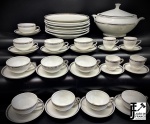 PORCELANA - Conjunto de porcelana branca com borda prateada, composto de: sopeira, 10 xícaras de chá e 8 xícaras de café e 7 pratos rasos. Med. 19x29 cm e 5,5 cm. Bicados.
