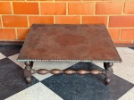 MOBILIÁRIO - Mesa de centro de madeira nobre, quatro pernas ligadas por traves torneadas, tampo revestido de curvim com tacheados. Med. 40x110x110 cm. No estado, necessita restauro. OBS.: Móveis UsadosLote de móvel antigo e usado, podendo apresentar marcas de uso e desgaste natural do tempo. Há possibilidade de danos ocultos e ou outras imperfeições.Não há garantia ou possibilidade de devolução após a aquisição. Recomenda-se inspeção prévia.
